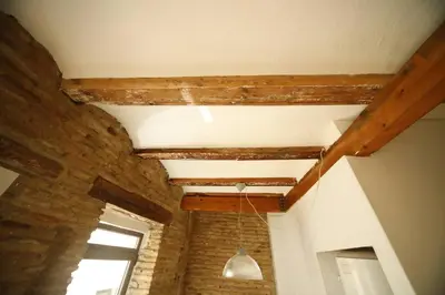 a room with wooden beams and a light hanging from the ceiling at Precioso apartamento en el centro histórico in Valencia