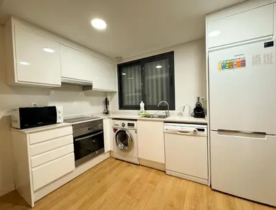 a kitchen with white cabinets and a washer and dryer at Luxury, design, relax, in historical street lift in Valencia
