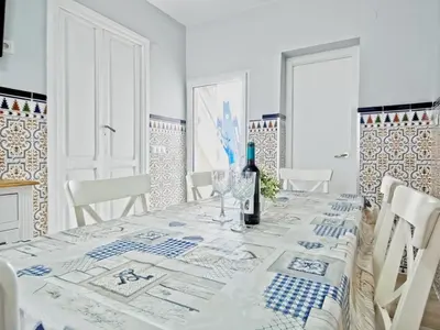 a white dining room with a table with a bottle of wine at CASA EN LA PLAYA VALENCIA EL PERELLO in Mareny Barraquetas