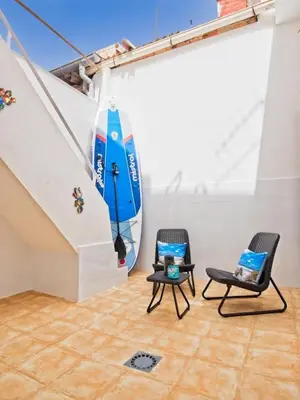 a room with two chairs and a surfboard on the wall at CASA EN LA PLAYA VALENCIA EL PERELLO in Mareny Barraquetas