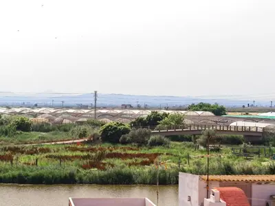 a view of a river with a bridge in the background at CASA EN LA PLAYA VALENCIA EL PERELLO in Mareny Barraquetas