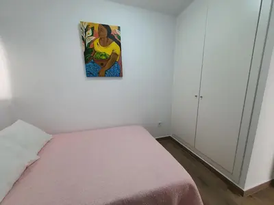 a bedroom with a bed with a painting on the wall at SingularStays Cullera IV in Cullera