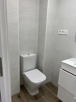 a white bathroom with a toilet and a sink at SingularStays Cullera IV in Cullera
