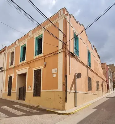an orange building on the side of a street at Casa Rural Los Pequeños (Monserrat) in Monserrat