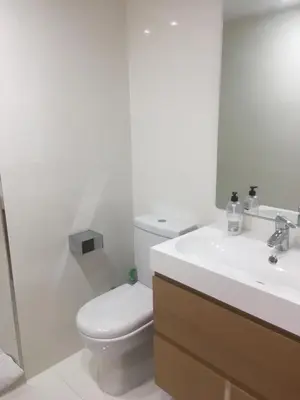 a white bathroom with a toilet and a sink at MAGNO CULLERA- Playa in Cullera
