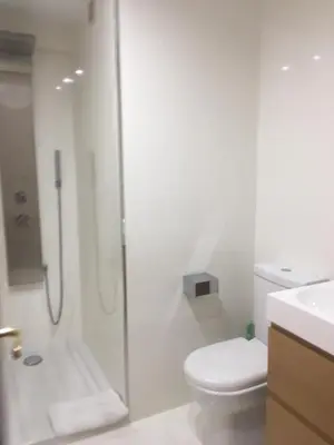 a white bathroom with a shower and a toilet at MAGNO CULLERA- Playa in Cullera