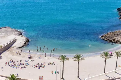 a group of people on a beach with the ocean at Cullera Apartment Faro in Cullera