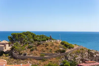 a retaining wall on a hill next to the ocean at Cullera Apartment Faro in Cullera