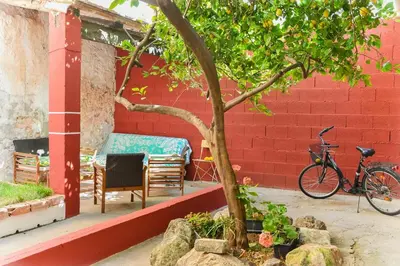 a bike parked next to a red brick wall with a table and chair at Casa Bienvenida - Carcaixent in Carcagente