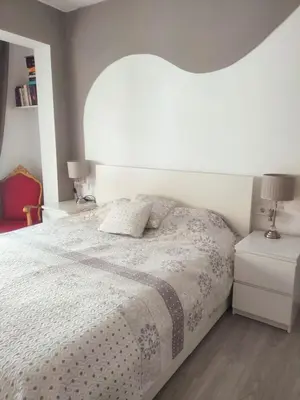 a bedroom with a bed with a white comforter at Vacansis Pintor Sorolla 2 in Cullera
