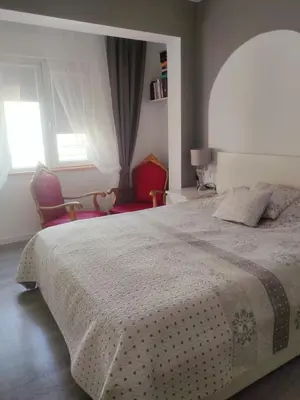 a bedroom with a large bed and two chairs at Vacansis Pintor Sorolla 2 in Cullera