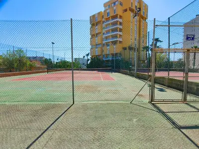 a tennis court with two tennis courts at Global Vacacional, Apartamento con piscina en Residencial Brezo in Canet de Berenguer