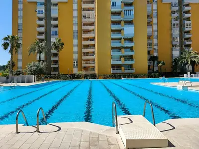 an empty swimming pool in front of a building at Global Vacacional, Apartamento con piscina en Residencial Brezo in Canet de Berenguer