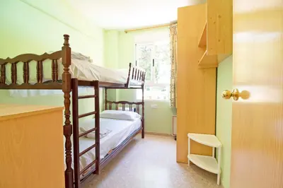 a bedroom with two bunk beds and a kitchen at Global Vacacional, Apartamento con piscina en Residencial Brezo in Canet de Berenguer