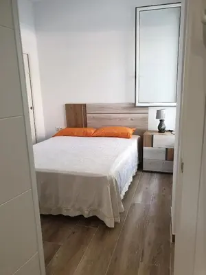 a bedroom with a bed with an orange pillow and a mirror at Premier Apartments in Valencia