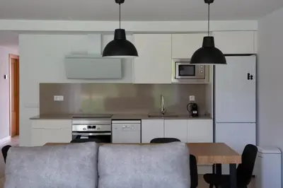 a kitchen with a couch and a table in a room at Jamaica Beach House in Puebla de Farnals