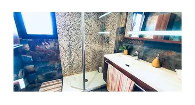 a bathroom with a shower and a sink and a mirror at Lovely penthouse condo with pool in Valencia