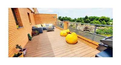 a deck with a couch and chairs on a balcony at Lovely penthouse condo with pool in Valencia