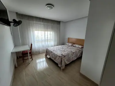 a bedroom with a bed and a table and a window at CA LAU in Burriana