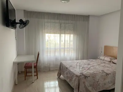 a bedroom with a bed and a desk and a window at CA LAU in Burriana