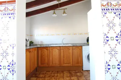 a kitchen with wooden cabinets and blue and white wallpaper at Global Vacacional, Apartamento céntrico en Canet d'en Berenguer in Canet de Berenguer