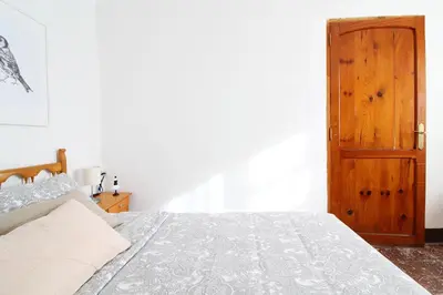 a bedroom with a bed and a wooden door at Global Vacacional, Apartamento céntrico en Canet d'en Berenguer in Canet de Berenguer