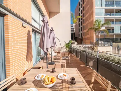 a balcony with tables and umbrellas on a building at MD Loft Valterna in Paterna