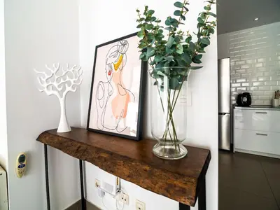a vase of flowers on a wooden table with a picture at MD Loft Valterna in Paterna