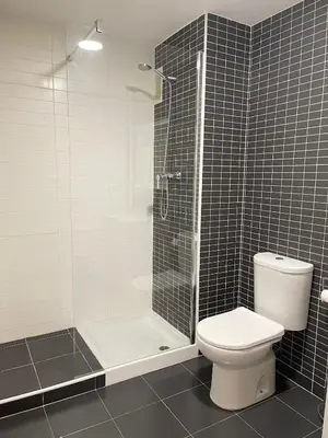 a bathroom with a toilet and a glass shower at Majestic Flats in Valencia