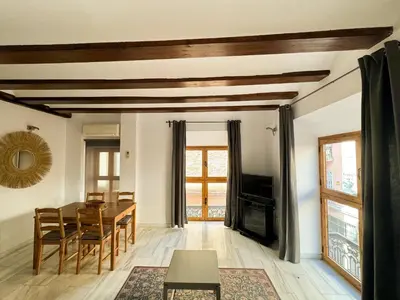 a living room with a table and chairs and a television at Duplex en el Carmen 1 in Valencia