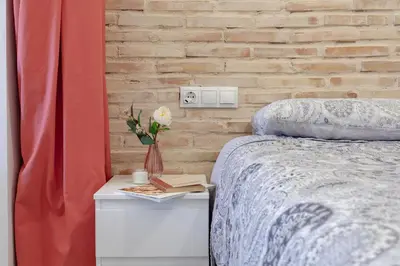 a bedroom with a bed and a brick wall at NB - Cozy loft steps from City of Arts & Sciences in Valencia