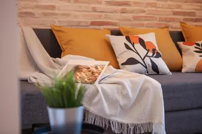 a blanket sitting on a couch with pillows at NC - Design Loft Steps from City of Arts & Sciences in Valencia