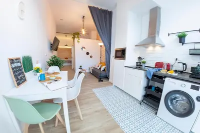 a kitchen and living room with a table and a washing machine at NC - Design Loft Steps from City of Arts & Sciences in Valencia