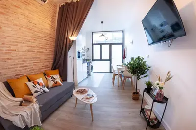 a living room with a couch and a flat screen tv at NC - Design Loft Steps from City of Arts & Sciences in Valencia