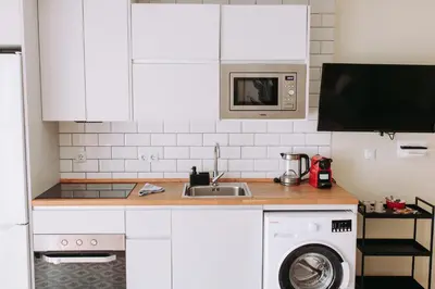 a white kitchen with a sink and a washing machine at Estelles D Apartment Close To Beach in Valencia