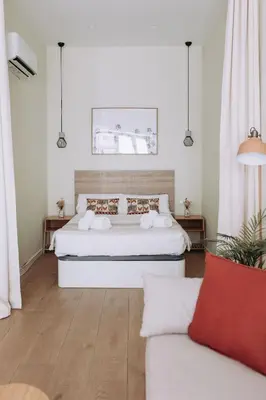 a bedroom with a white bed and a couch at Estelles D Apartment Close To Beach in Valencia