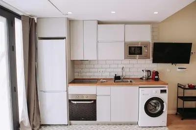 a kitchen with white cabinets and a washer at Estelles D Apartment Close To Beach in Valencia