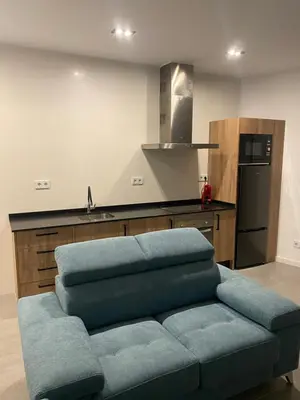 a living room with a blue couch in a kitchen at Cantalar White in Anna