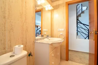 a bathroom with a sink and a mirror at Global Vacacional, Adosado en primera linea de playa con vistas al mar in Sagunto