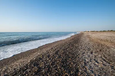 a rocky beach with the ocean in the background at Global Vacacional, Adosado en primera linea de playa con vistas al mar in Sagunto