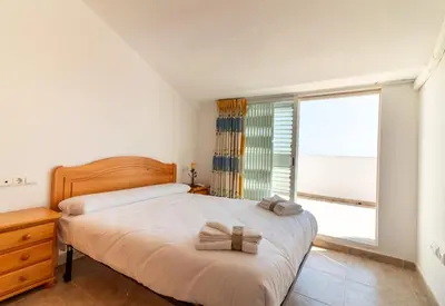 a bedroom with a bed and a large window at Global Vacacional, Adosado en primera linea de playa con vistas al mar in Sagunto