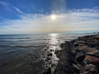 a view of the ocean with the sun in the sky at Lowenva beach apartment in Canet de Berenguer