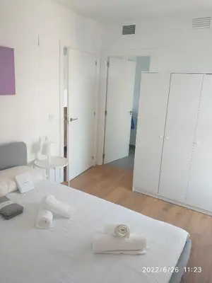 a bedroom with a white bed with towels on it at Bonito apartamento con piscina cerca de la playa. in Canet de Berenguer