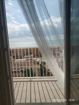 a window with a view of the ocean from a balcony at Bonito apartamento con piscina cerca de la playa. in Canet de Berenguer