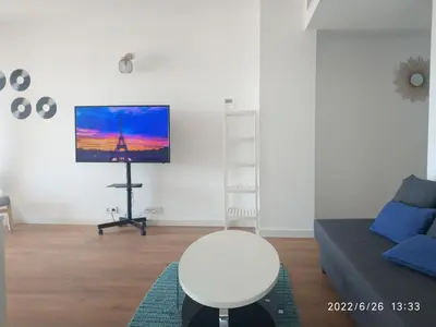 a living room with a couch and a tv at Bonito apartamento con piscina cerca de la playa. in Canet de Berenguer