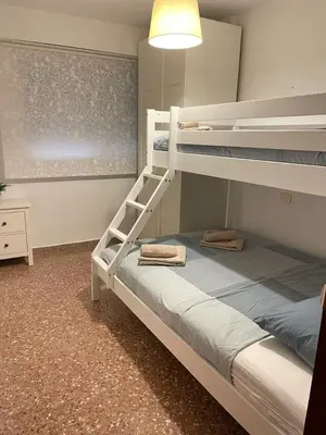 a bedroom with two bunk beds and a lamp at UIM Mediterraneo Isabel 23 Wifi in Puerto de Sagunto