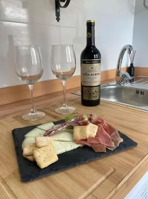 a plate of food and two wine glasses on a counter at Coqueto Apartamento de Playa con Piscina y Terraza in Valencia