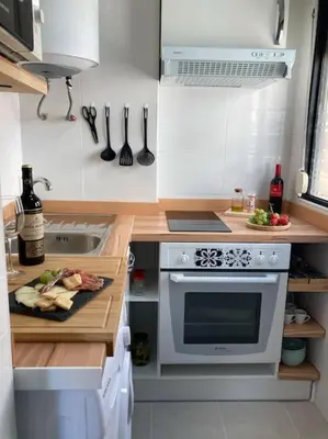 a kitchen with a counter with a sink and a stove at Coqueto Apartamento de Playa con Piscina y Terraza in Valencia
