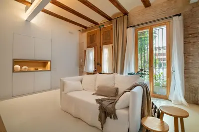 a living room with a white couch and a window at Design house with swimming pool near the sea in Valencia