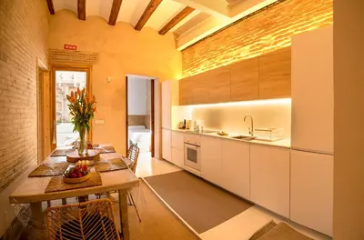 a kitchen with white cabinets and a table in a room at Design house with swimming pool near the sea in Valencia
